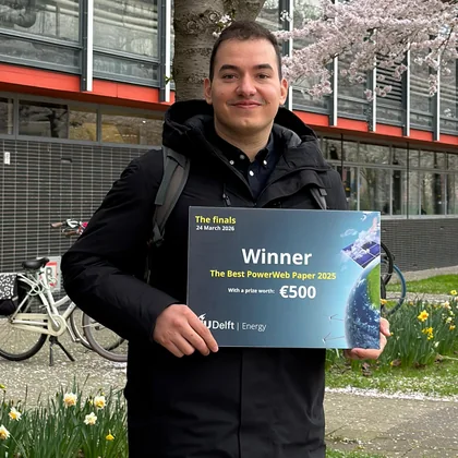 Holding the Best PowerWeb Paper 2025 winner board at TU Delft